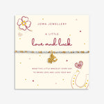 A Joma Jewellery bracelet on a cream display card. The bracelet features small white and gold beads with a gold elephant charm.