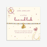 A Joma Jewellery bracelet on a cream display card. The bracelet features small white and gold beads with a gold elephant charm.