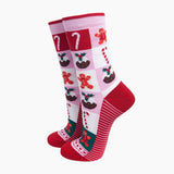 A pair of Christmas-themed crew socks featuring a pink and white checkered pattern with gingerbread men, candy canes, and mulberries, accented with solid red heels, toes, and cuffs.