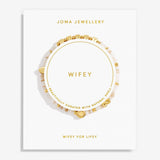 A Joma Jewellery 'Wifey' bracelet displayed on a white branded card. The bracelet features natural shell beads with small gold charms, including a heart and a square charm, and is presented on a clean white background.