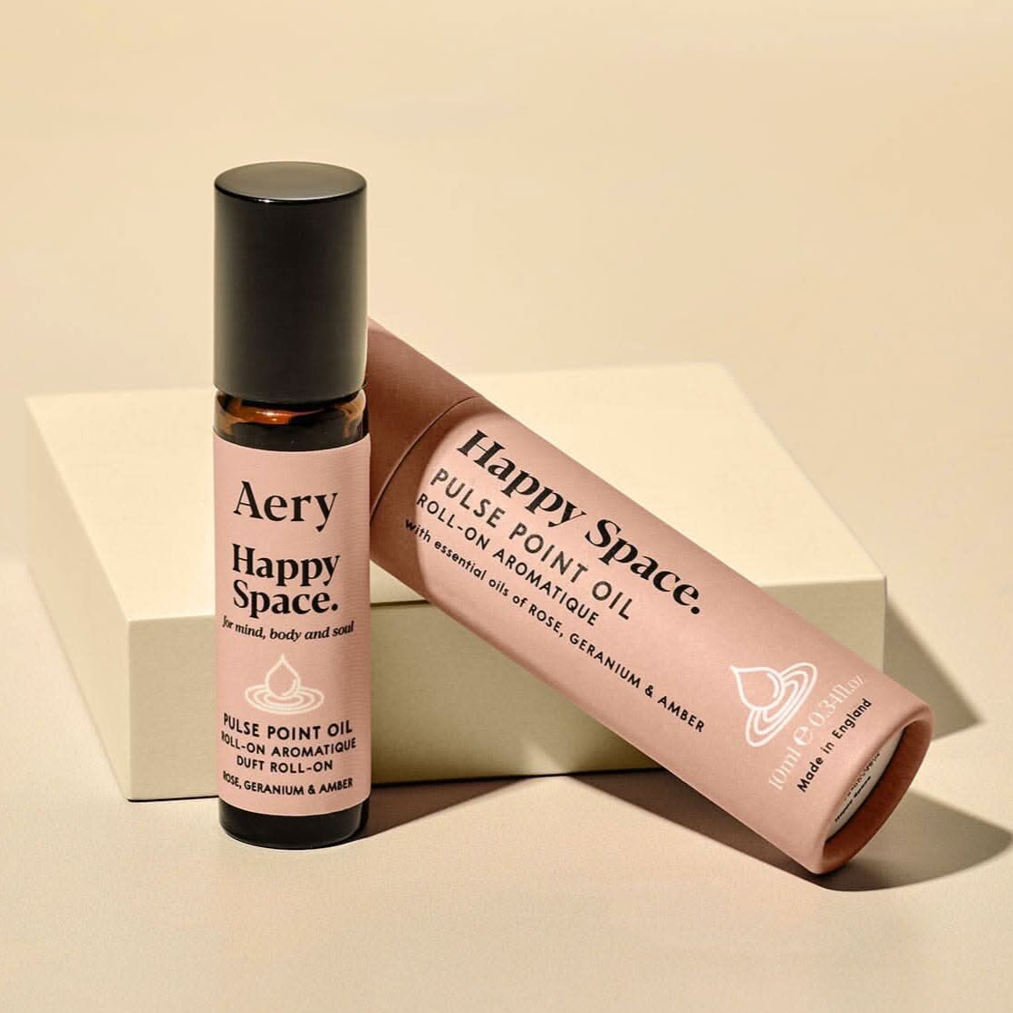 Aery Happy Space pulse point oil bottle and packaging on a beige background