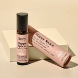Aery Happy Space pulse point oil bottle and packaging on a beige background