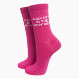 A pair of bright pink crew socks with white text reading 'NAUGHT IS THE NEW NICE' on a clean white background.