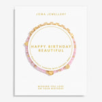 A Joma Jewellery 'Happy Birthday Beautiful' bracelet gift set on a white display card. The set features a pink beaded bracelet with gold cube charms, a pink beaded bracelet with gold heart charms, and a gold chain bracelet with gold cube charms, all arranged on a white card with gold lettering.