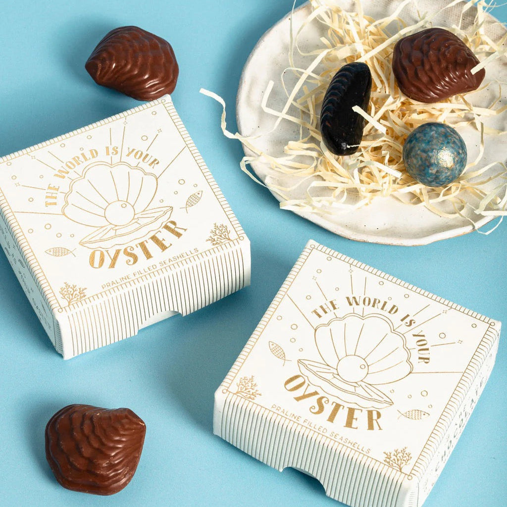 Chocolate oysters in decorative boxes on a blue background