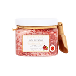 Sunday Rain Bath Crystals in a clear jar with a white lid, featuring pink pomegranate bath salts and a small wooden scoop on a white background.